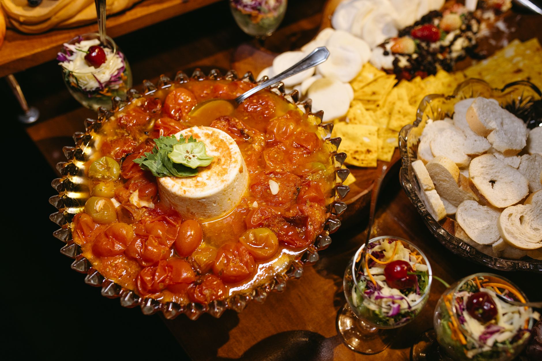 Savory gourmet cheese platter with fresh cherry tomatoes and assorted breads. Perfect for catering and events.