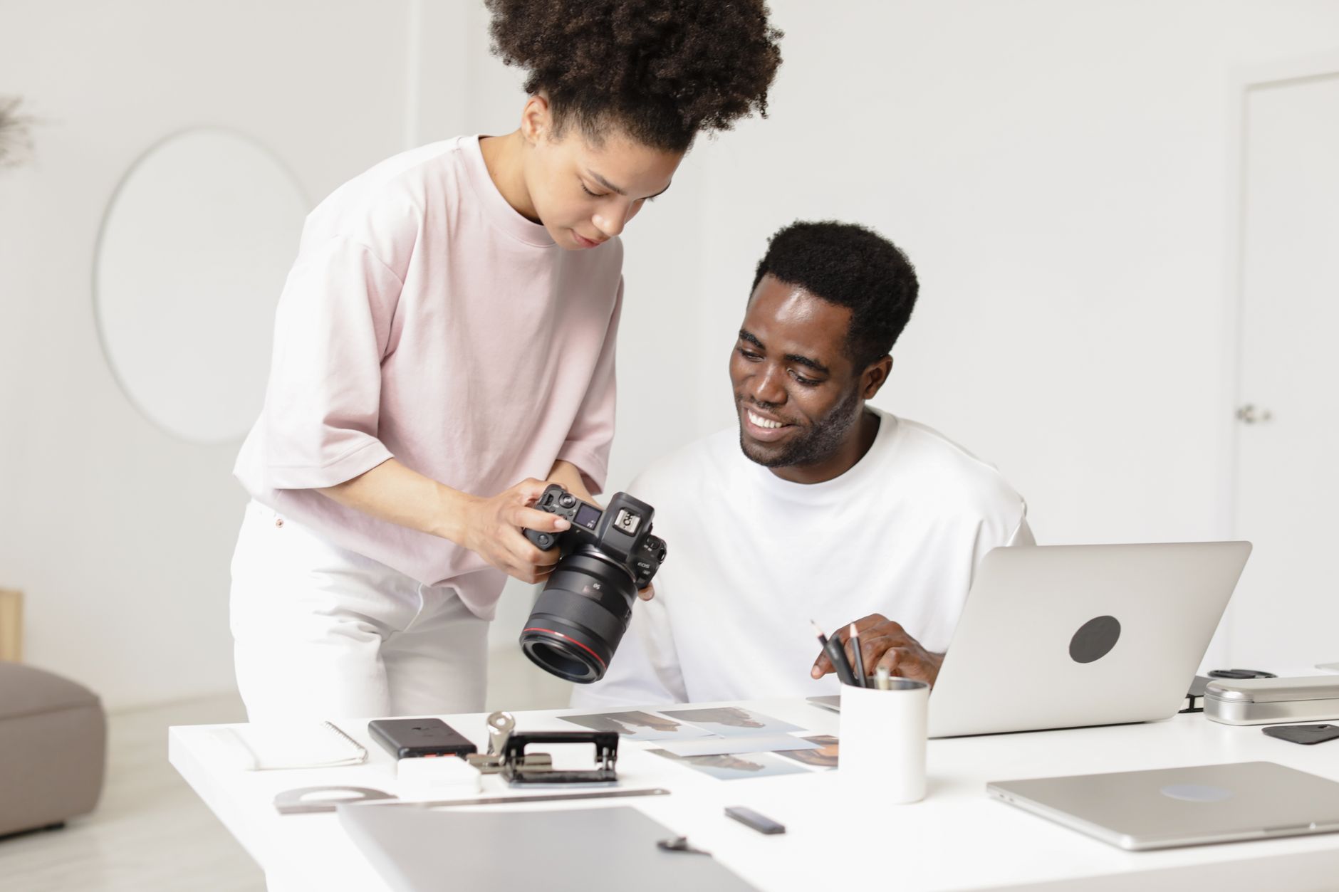 Professional photographers collaborating on a project with camera and laptop.