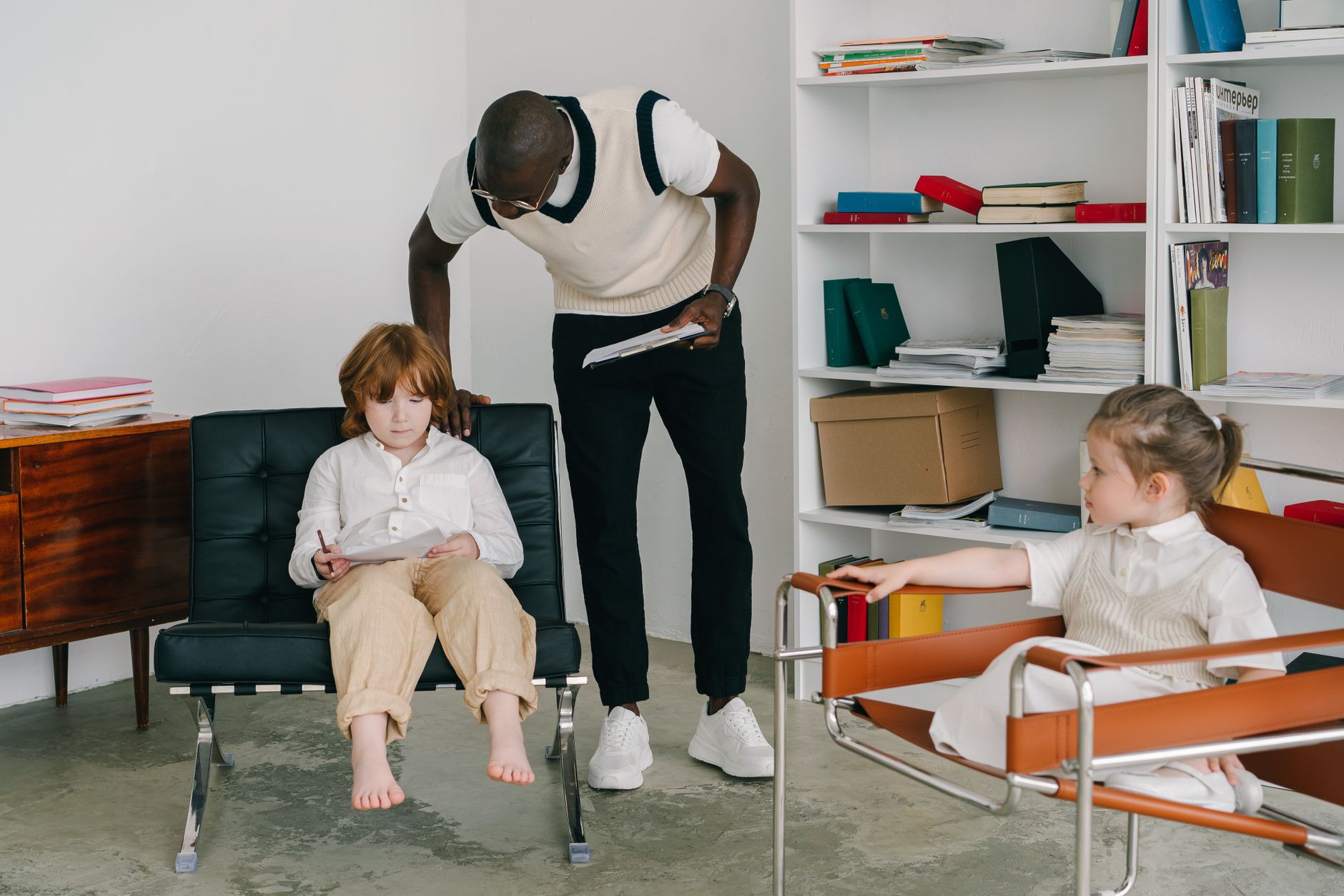 Therapist engaging with children in a modern office environment, focusing on child development.