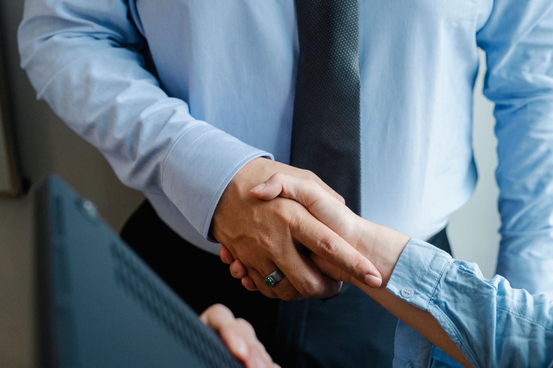 High angle of crop unrecognizable male and female business partners in formal clothes shaking hands after successful dea