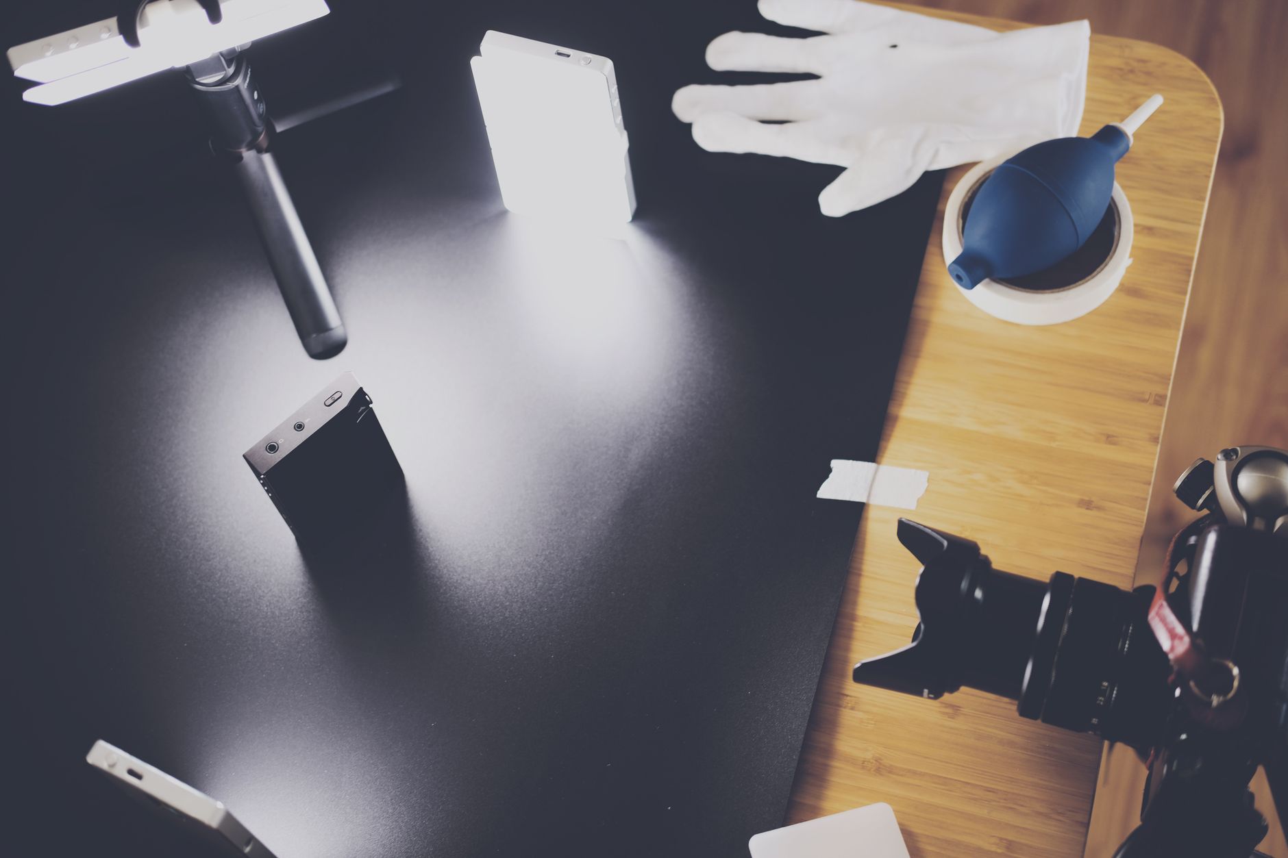 A photography setup with lighting equipment, camera, and accessories on a wooden table.