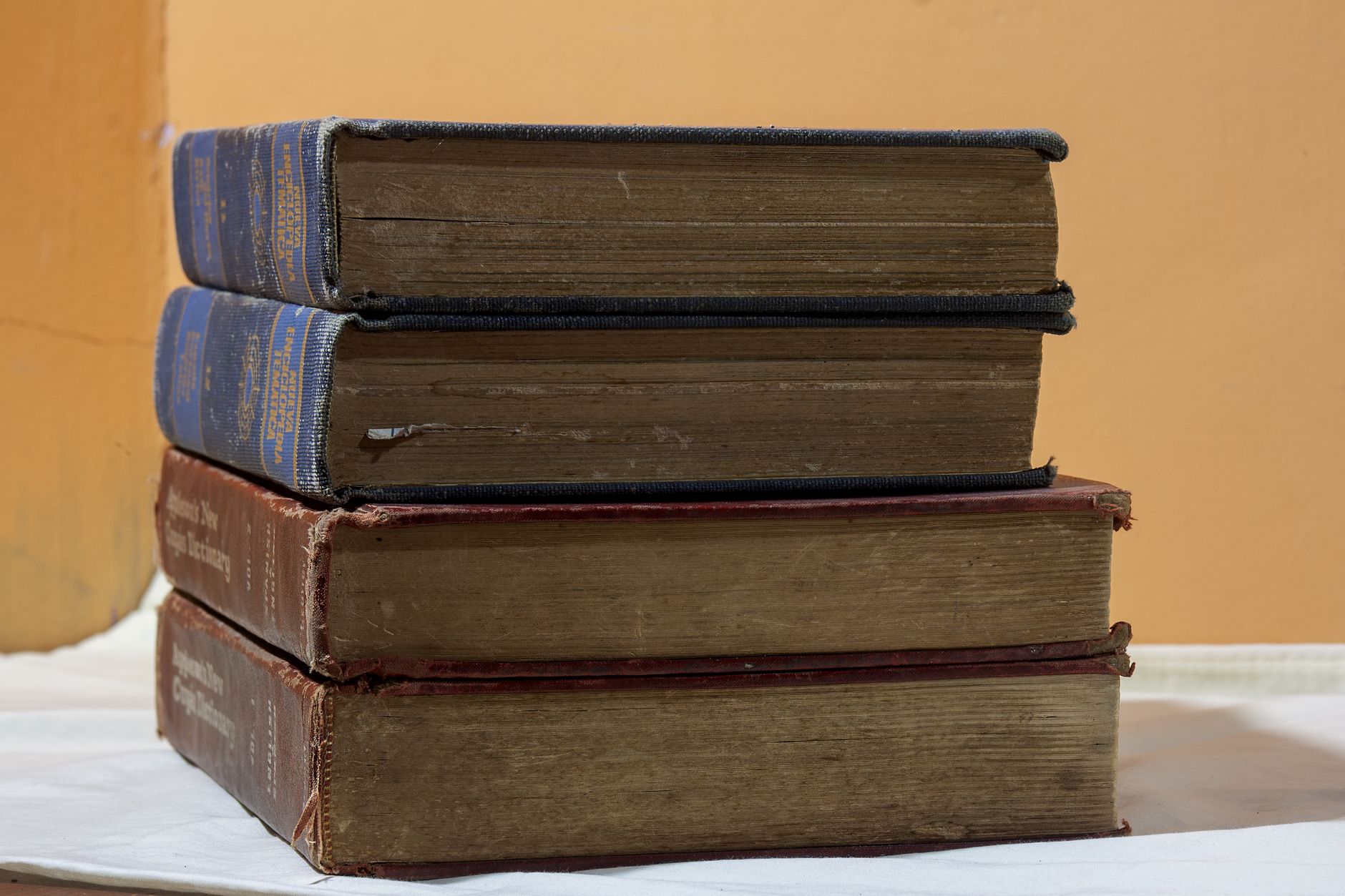 A stack of vintage books on a wooden table, capturing classic literary charm.